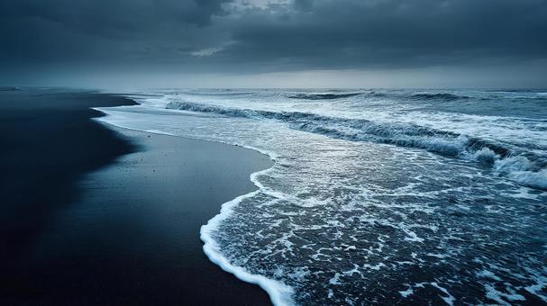 紺色に沈む荒れた海と空の写真