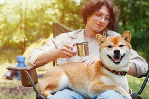 犬を抱く男性キャンパー 男性,外国人,犬の写真素材