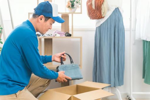 小物・雑貨の荷造りする引越し業者の男性 小物・雑貨の荷造りする引越し業者の男性 リサイクルショップ,荷造り,引越しの写真素材