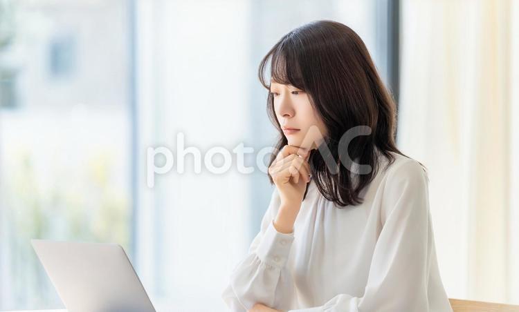 パソコンの画面を見ながら考える女性 女性,ビジネス,パソコンの写真素材
