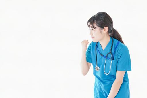 患者を応援する笑顔の若いナース 患者を応援する笑顔の若いナース ガッツポーズ,手術,白衣の写真素材