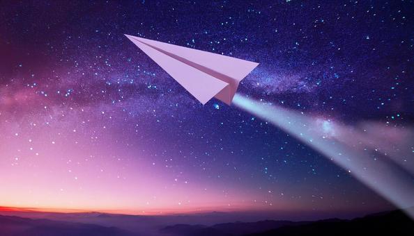 宇宙に向かって飛んでいる紙飛行機の写真