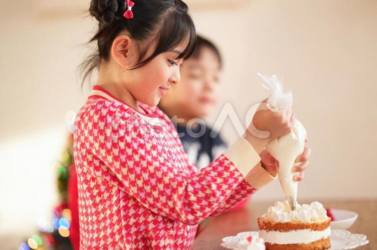 生クリームを絞っている横向きの女の子 女の子,クリスマス,ケーキの写真素材