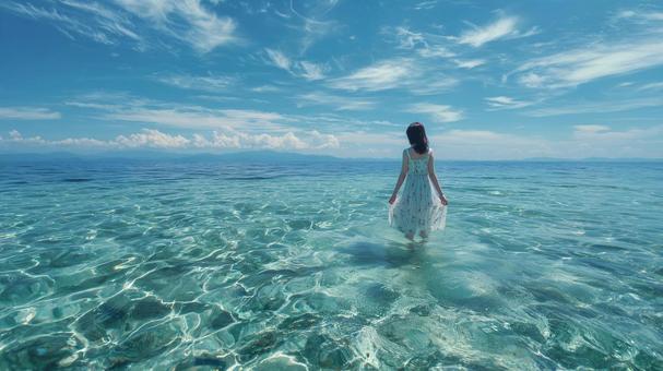 綺麗な海の浅瀬を歩くワンピースを着た女性 綺麗な海の浅瀬を歩くワンピースを着た女性の写真