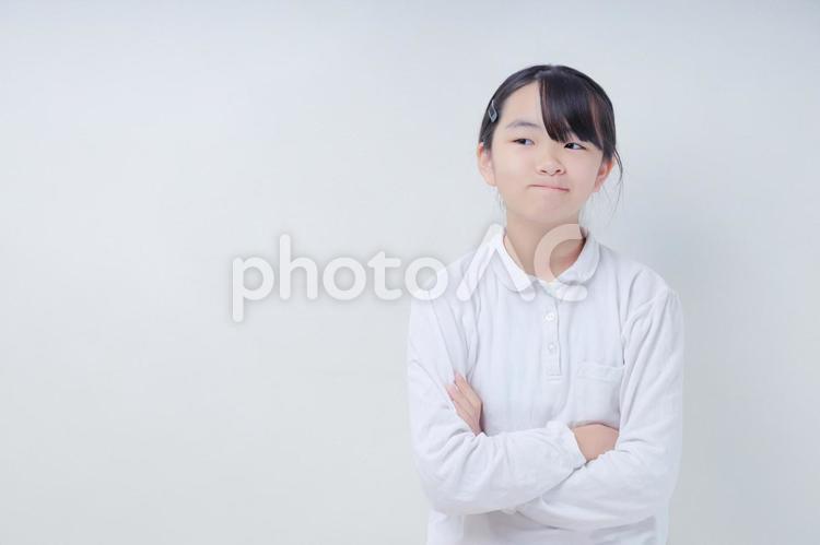 口を一文字にし腕組みをした女の子｜白背景 女性,日本人,若いの写真素材