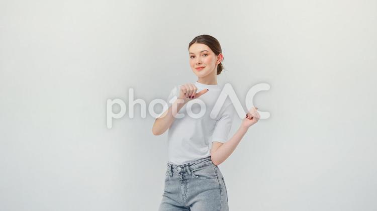 カメラ目線でポーズする笑顔の女性 女性,指差し,サムズアップの写真素材