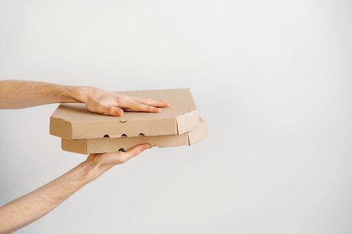 2個重ねたピザ箱を差し出す手 配達,フードデリバリー,テイクアウトの写真素材