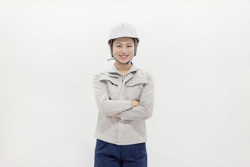 腕組みをする作業服の女性 腕組みをする作業服の女性 女性,ヘルメット,腕組みの写真素材