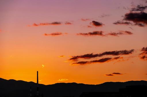 工場の煙突を背景にしたオレンジ色の夕景 工場の煙突を背景にしたオレンジ色の夕景の写真