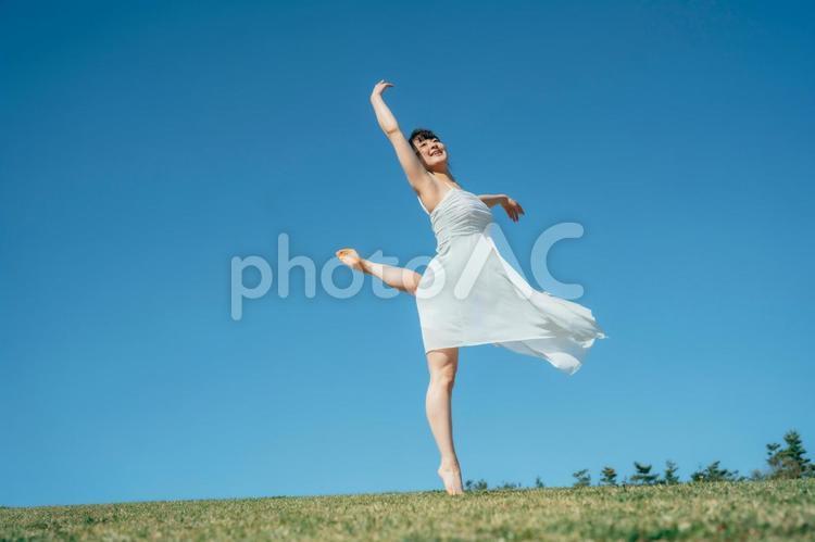 空と白いワンピースの踊る女性（アラベスク） 女性,空,美容の写真素材