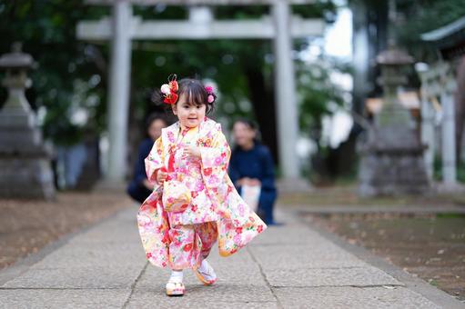 鳥居の前を走る女の子 鳥居の前を走る女の子の写真