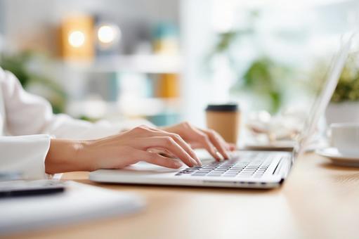 女性の手とノートPC 女性の手とノートPCの写真
