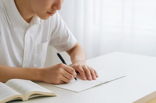 集中して書き込む高校生男子 集中して書き込む高校生男子の写真