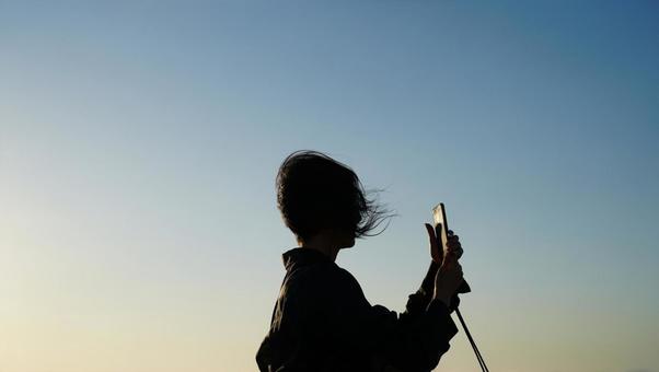 夕暮れの港に立つ女性 夕暮れの港に立つ女性の写真
