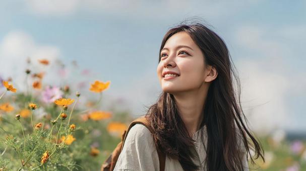 花に囲まれ、リラックスした表情の女性 花に囲まれ、リラックスした表情の女性の写真