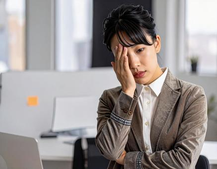 頭を抱えて頭痛に悩む女性 頭を抱えて頭痛に悩む女性の写真