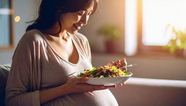 食事を美味しそうに食べる妊婦の写真