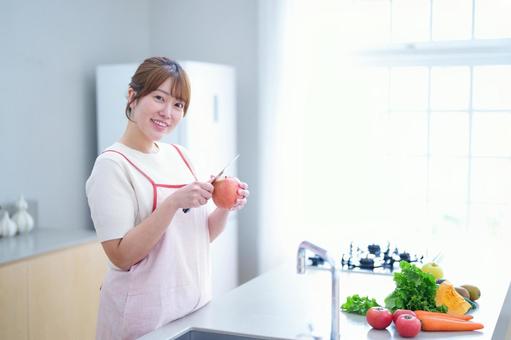 リンゴを持ちカメラ目線の女性 女性,リンゴ,皮むきの写真素材