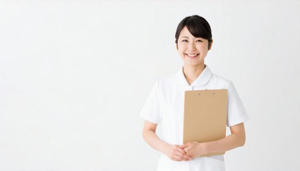 ファイルを抱える笑顔の日本人女性看護師 ファイルを抱える笑顔の日本人女性看護師の写真