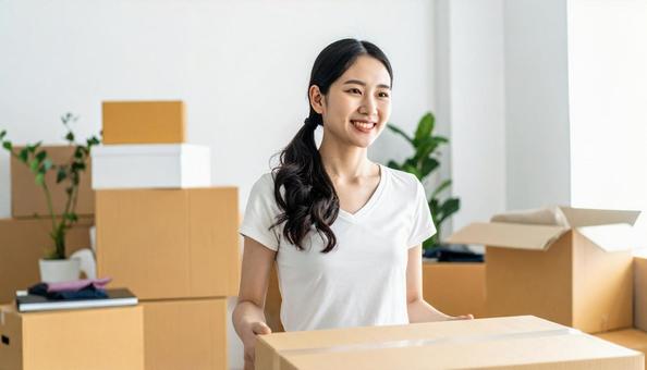 微笑みながら引越し作業をする女性 微笑みながら引越し作業をする女性の写真
