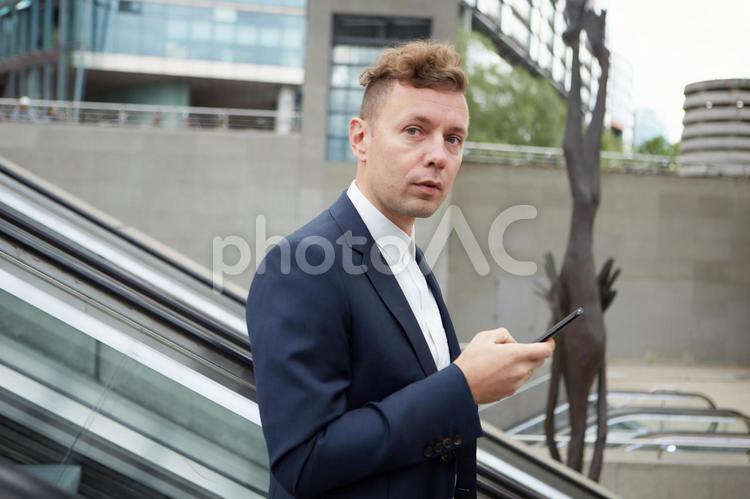 屋外のエスカレーターに乗るビジネスマン8 ビジネスマン,男性,外国人の写真素材