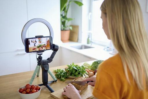 料理動画を撮影中の女性の後ろ姿 女性,料理,包丁の写真素材