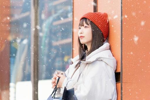 雪が降る冬の街でショッピングをする女性 冬,女性,街の写真素材