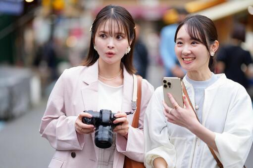 カメラやスマホを持ち微笑む女性たち 女性,スマートフォン,カメラの写真素材