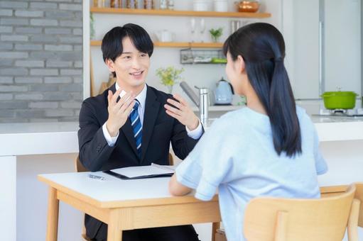 リビングで女性と商談をするビジネスマン リビングで女性と商談をするビジネスマン 営業,金融,保険の写真素材