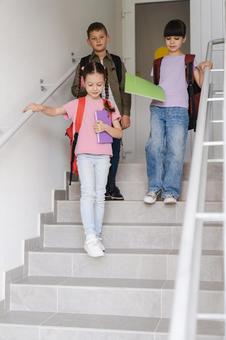 ノートを持って階段を降りる生徒たち 男の子,女の子,子どもの写真素材