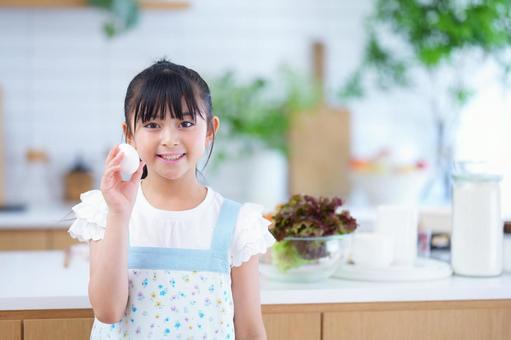 料理の準備をする明るい表情の少女 女の子,卵,持つの写真素材