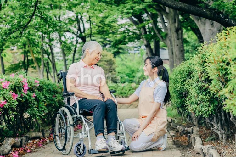 車椅子に乗った高齢者女性と女性スタッフ 介護士,看護師,介護福祉士の写真素材