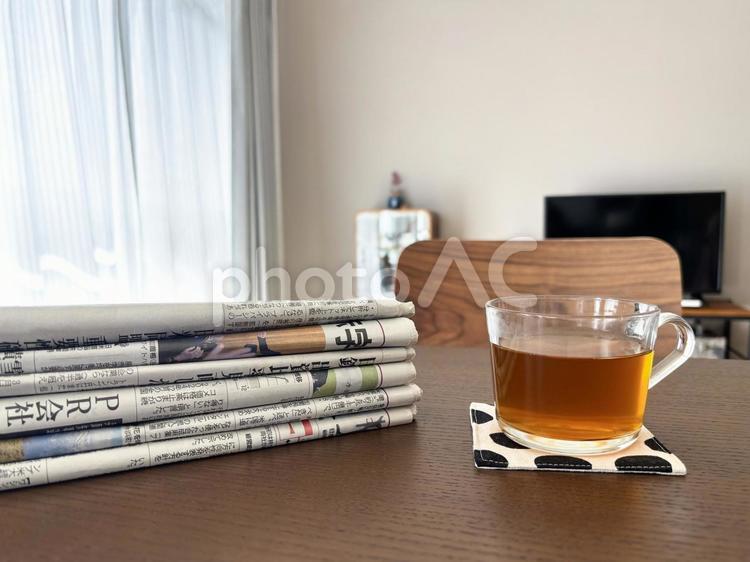 テーブルの上に置かれた新聞紙の束 新聞紙,新聞,紙媒体の写真素材