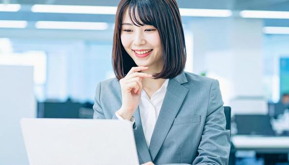 パソコンと笑顔の女性 パソコンと笑顔の女性の写真