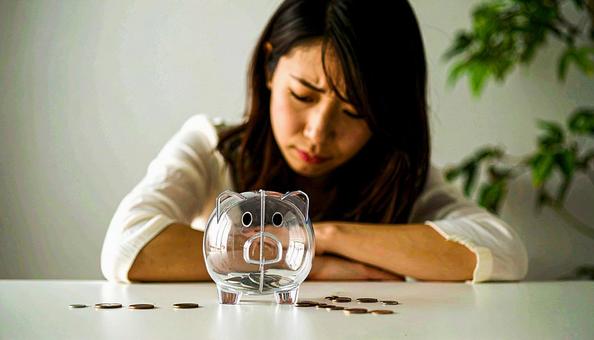 投資か貯金、どちらがいいか悩む若い女性の写真