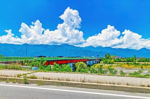 夏雲たなびく安曇野、鮮やかな緑と赤の梓橋 夏雲たなびく安曇野、鮮やかな緑と赤の梓橋 安曇野,夏,夏空の写真素材