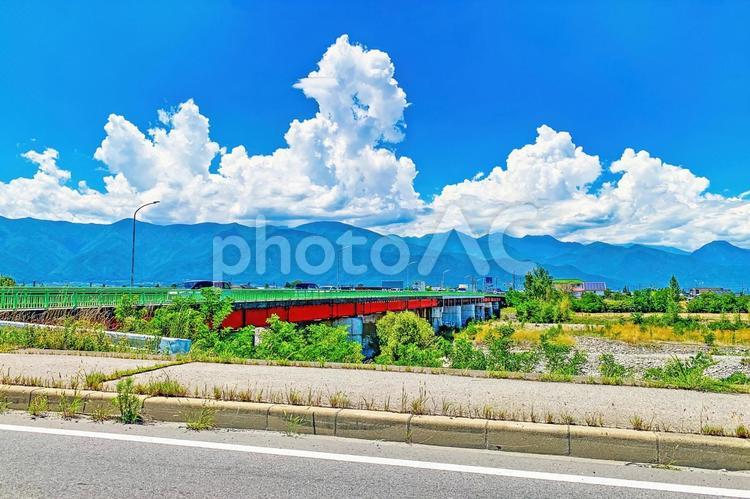 夏雲たなびく安曇野、鮮やかな緑と赤の梓橋 安曇野,夏,夏空の写真素材