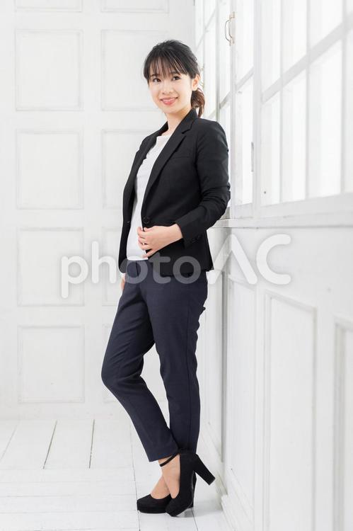 白い部屋に立ってポーズをとる、ジャケットを着た若い女性 女性,立つ,ジャケットの写真素材
