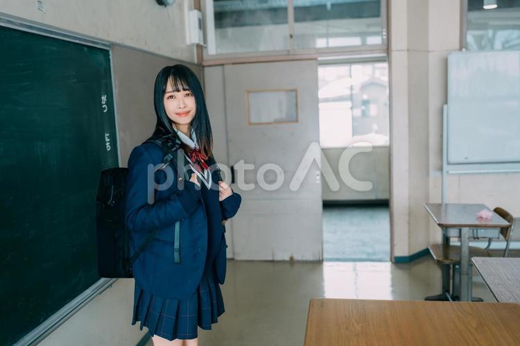 リュックを背負って立つ笑顔の女子高校生 女子高校生,高校生,学生の写真素材