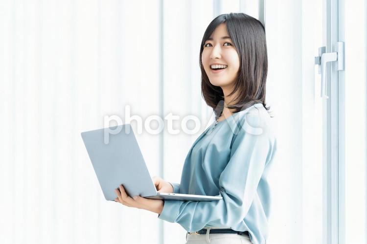 ノートパソコンを持つ笑顔の女性 女性,ビジネス,笑顔の写真素材
