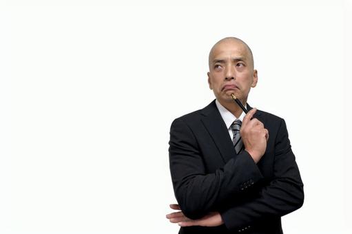 ペンを持って腕組みで悩むスーツの中年男性 男性,ビジネス,スーツの写真素材