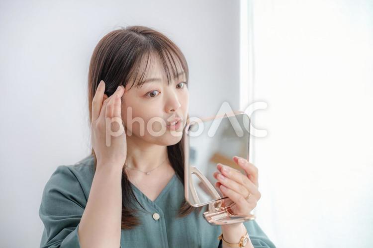 肌を気にする清楚な女性 女性,若い女性,アジアンの写真素材