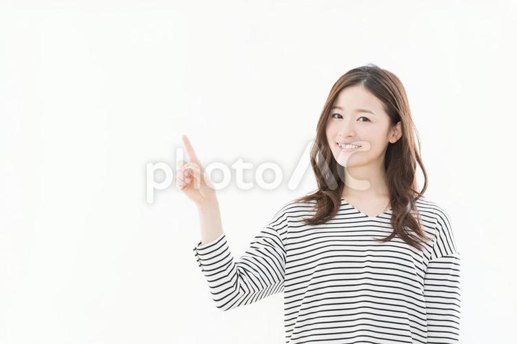 若い女性　指差し　 女性,笑顔,指差しの写真素材
