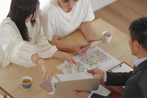 営業マンと家づくりの相談をする若い夫婦 営業マンと家づくりの相談をする若い夫婦 住宅,家,新築の写真素材
