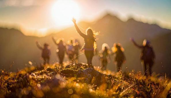 夏山で朝日に向かって手をあげる登山者 夏山で朝日に向かって手をあげる登山者の写真