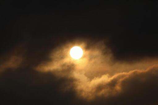 黒い雲の中のオレンジ色の太陽のある空 黒い,雲,中の写真素材