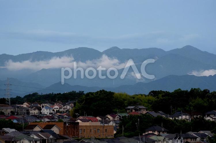 住宅地の向こうの雲がかかる山並み 風景,山,青空の写真素材
