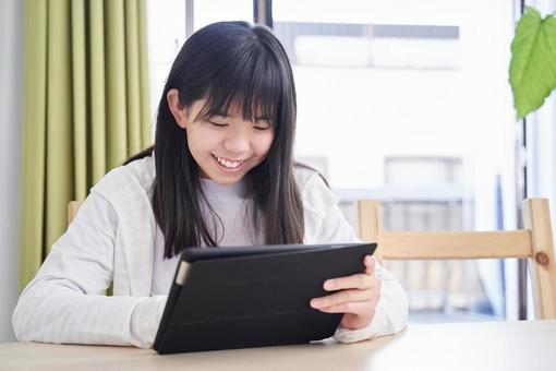 Junior high school girls looking at a tablet in the living room, JPG Junior high school girls looking at a tablet in the living room, JPG