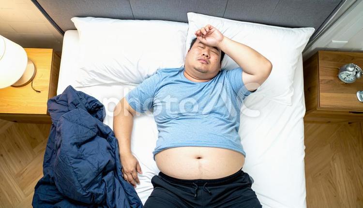 肥満で疲れやすく、額に手をやる男性 太い,デブ,大きいの写真素材