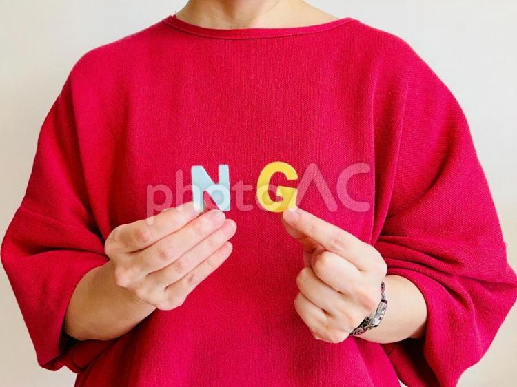 NGの文字を持つ女性 ng,ダメ,ノーの写真素材